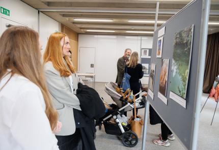 Attendees view the photo exhibition from the MORE project