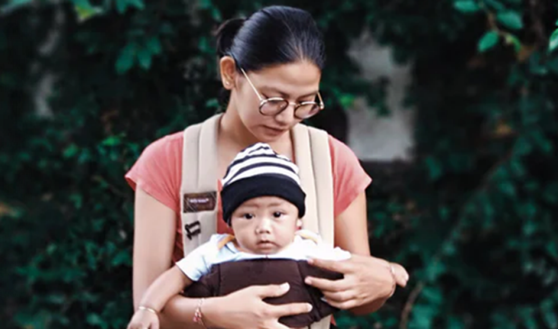 South East Asian mother with baby in sling