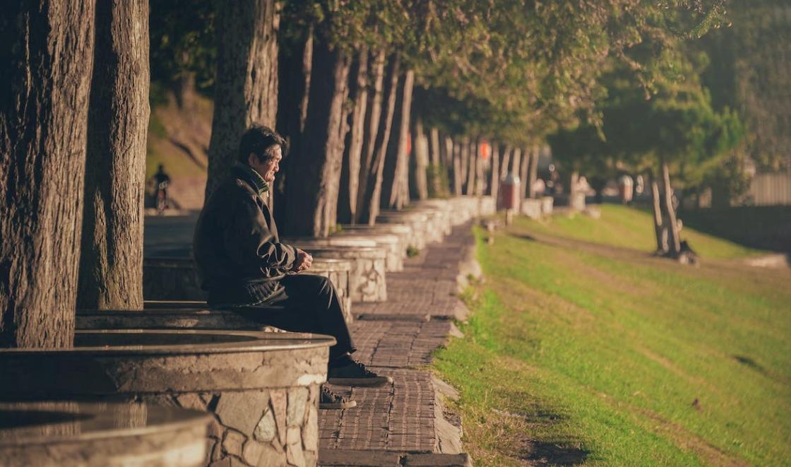 Man sitting by trees looking at view