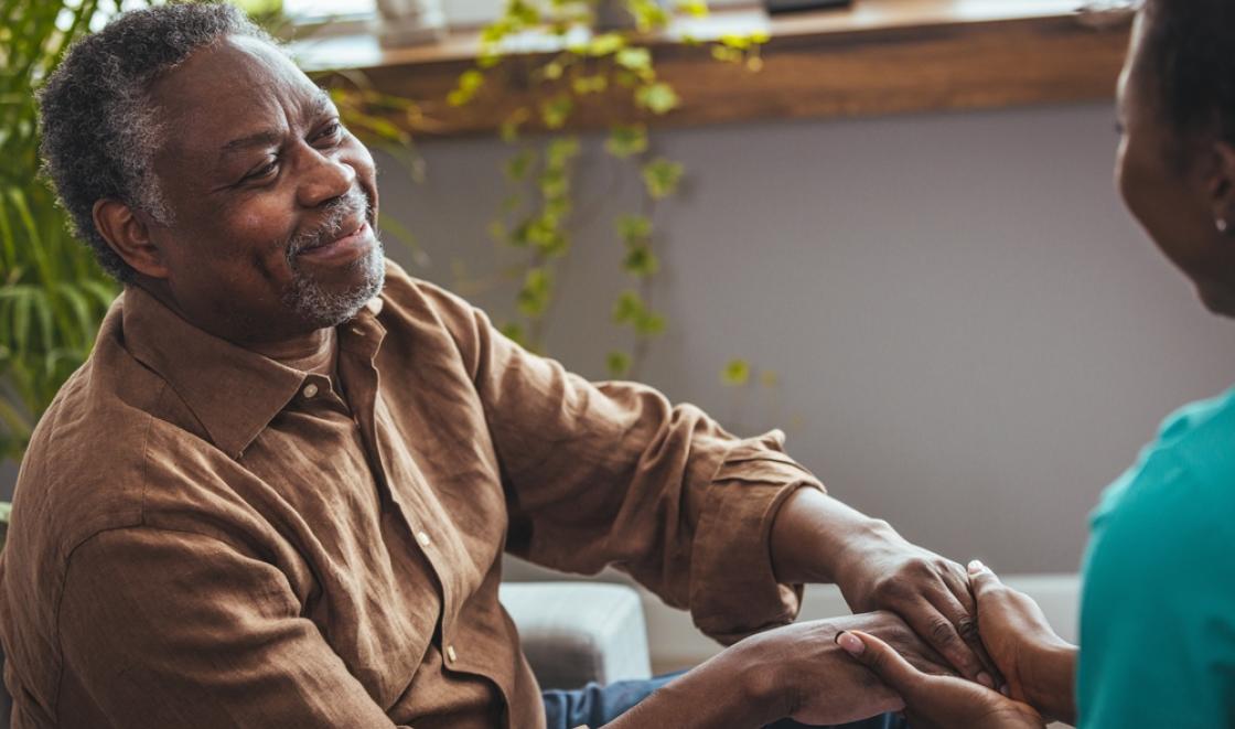 Older Black man holding hands with woman