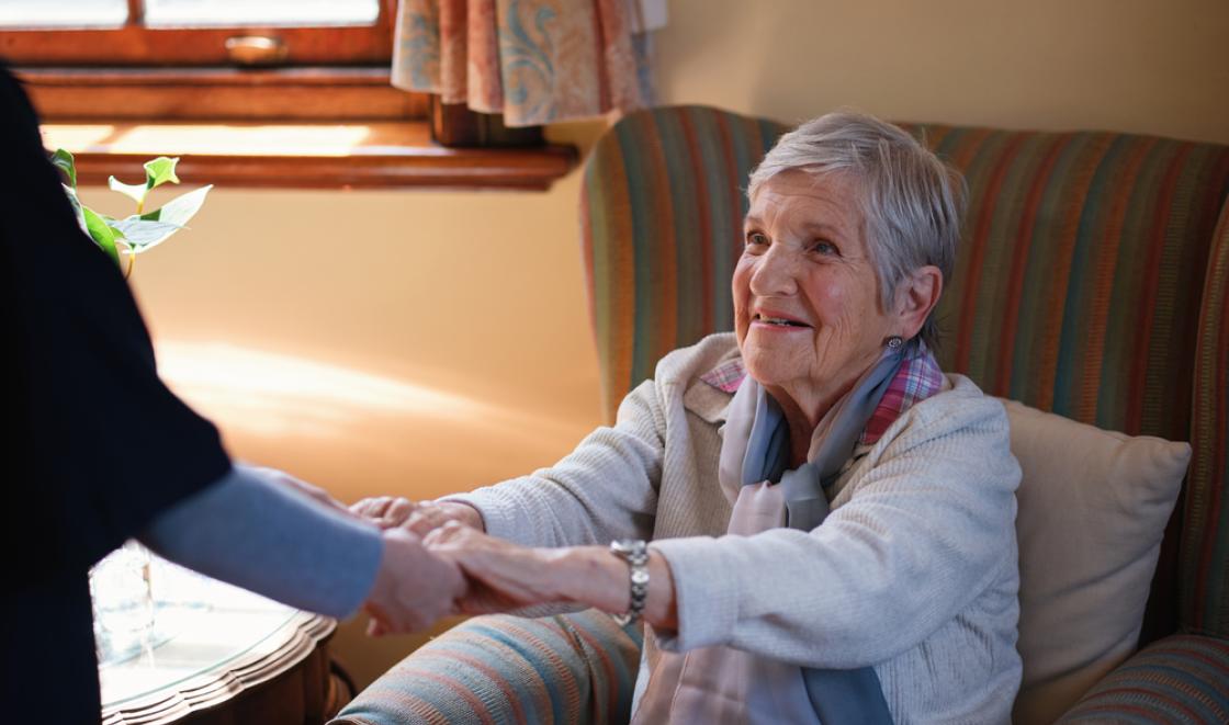 Old woman holding hands with nurse