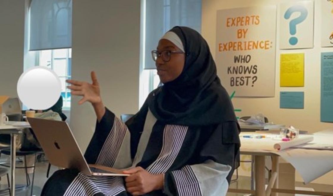 Zenab presenting at exhibition on Experts by Experience